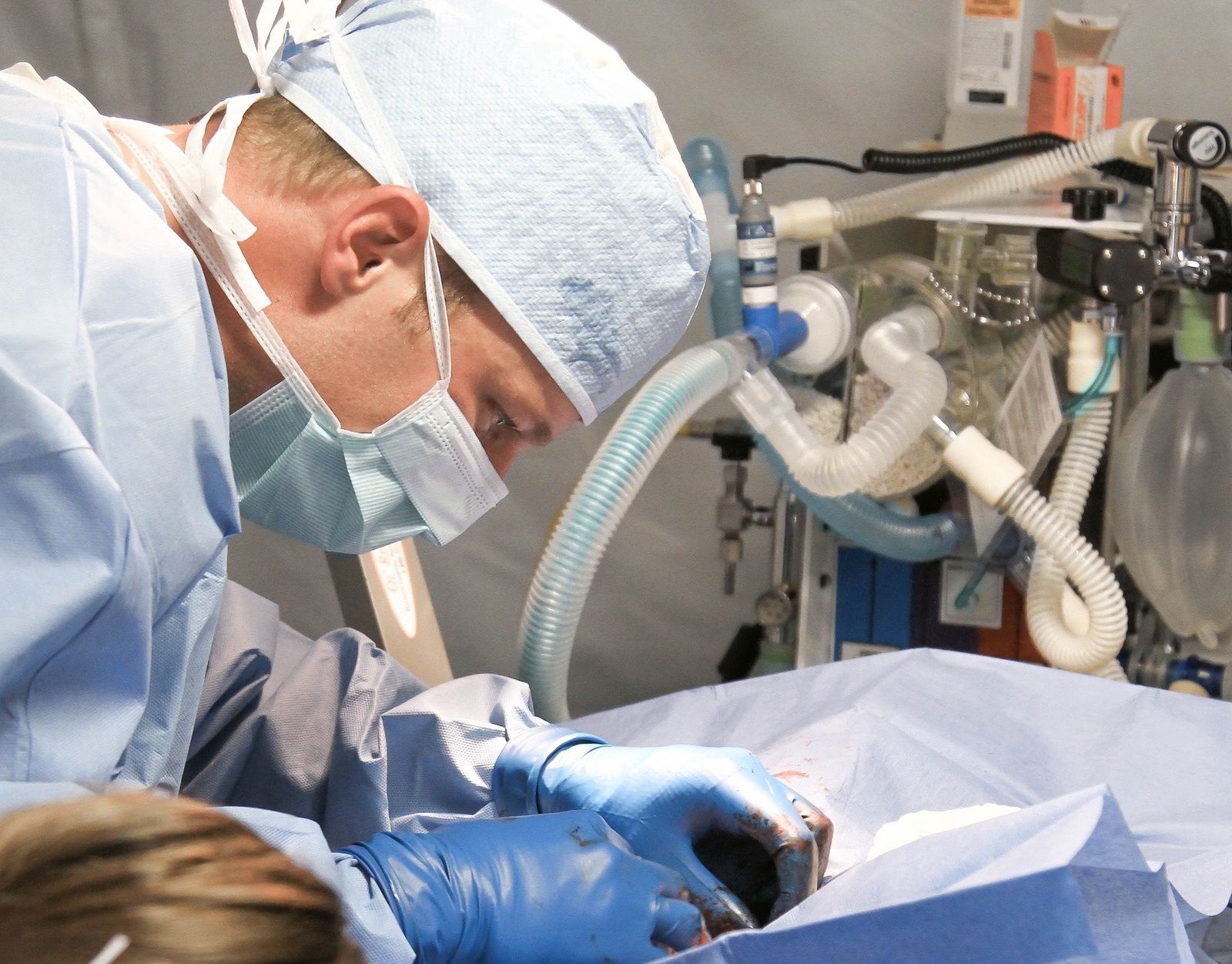 Ein Arzt komplett mit Maske und OP-Kleidung während einer Operation