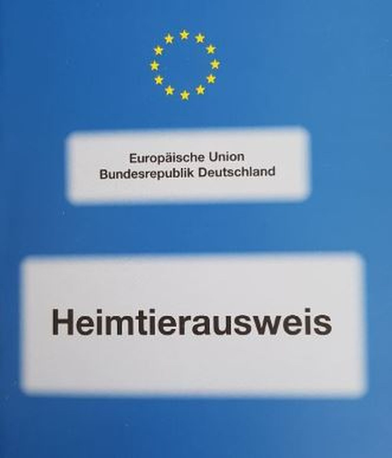 Bild des blauen Heimtierausweises mit dem Stern aus gelben EU-Sternen oben und zwei weißen Textfeldern mit schwarzen Druckbuchstaben. Im oberen steht in kleinerer Schrift in zwei Zeile "Europäische Union Bundesrepublik Deutschland". Im unteren Textfeld steht in größerer Schrift "Heimtierausweis" 